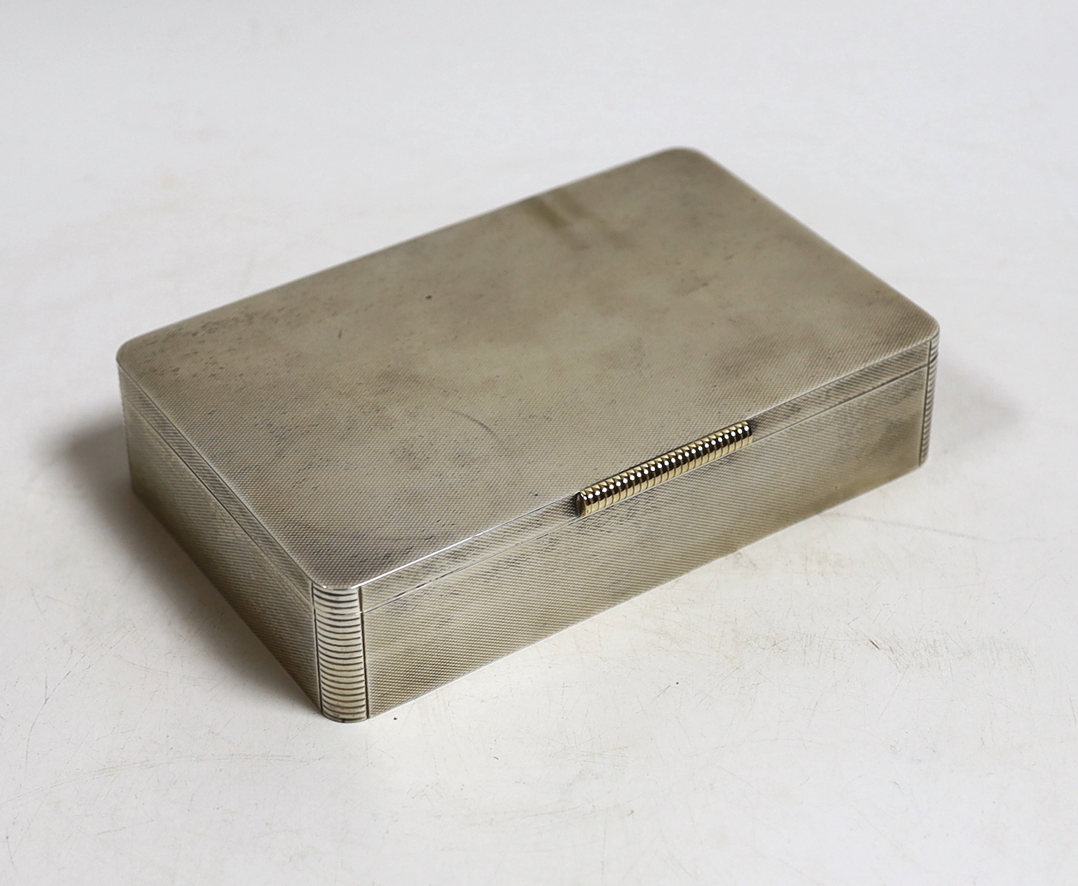 A George VI engine turned silver mounted rectangular cigarette box, Padgett & Braham Ltd, London, 16.5cm.